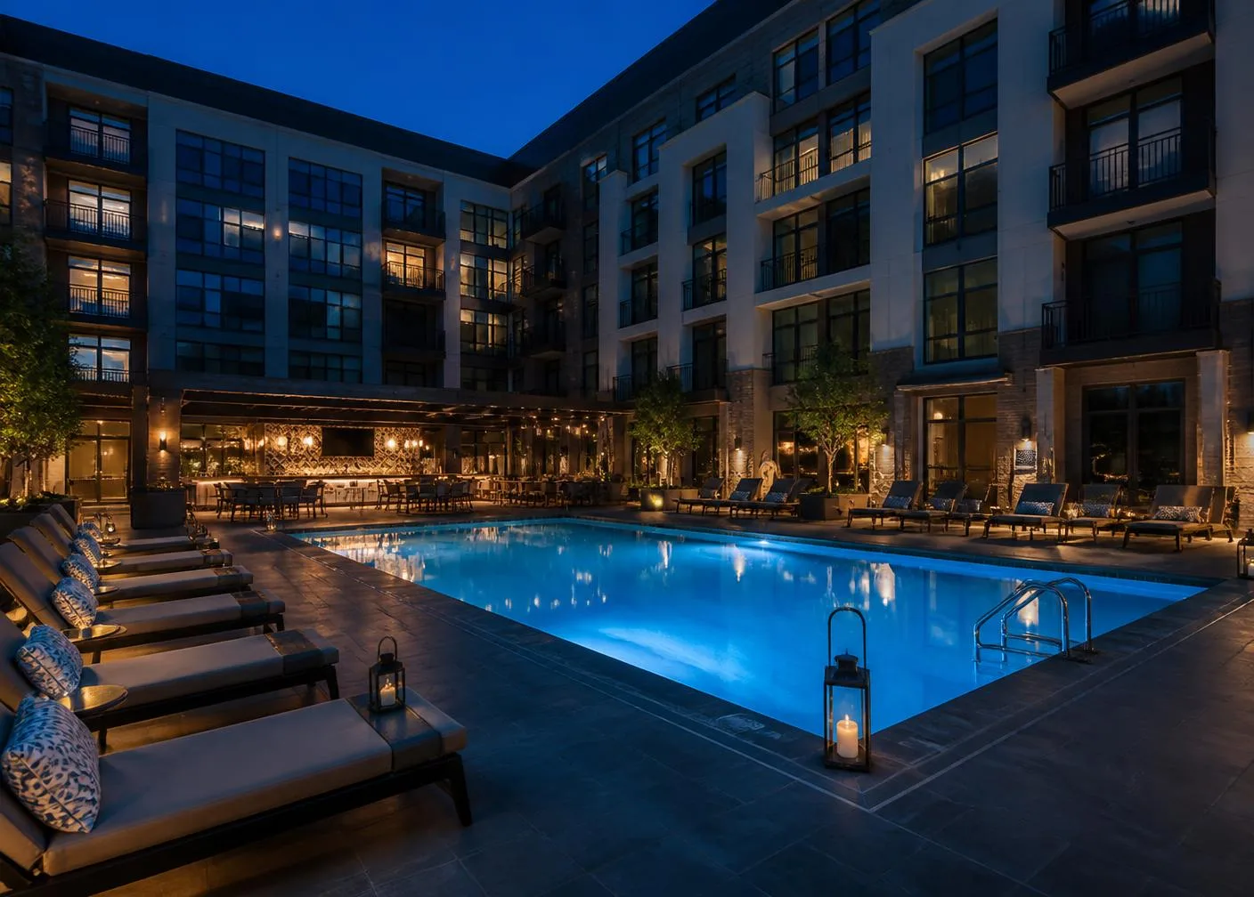 Lit commercial courtyard pool at a multifamily property in the evening
