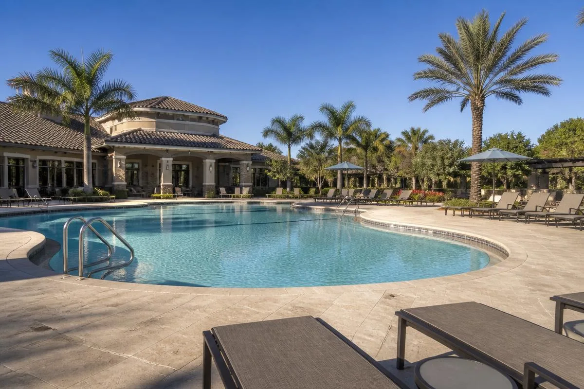 Large commercial community pool with clean decking and lounge seating